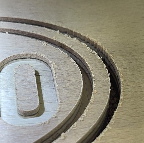 1. Intricate layered wood cuts forming a circular design for maker projects.