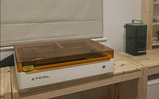 XTool M2 laser engraver and cutter placed on a wooden workbench in our home studio.