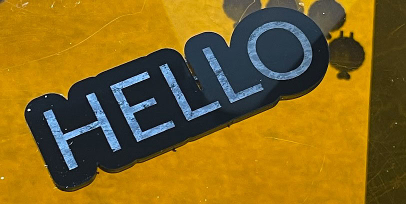 'HELLO' sign cut out of black acrylic on the xTool M2