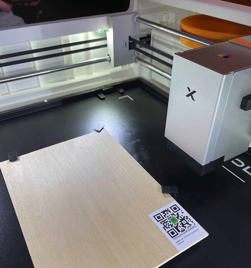 XTool M2 laser engraver and cutter with a wooden sample and QR code.